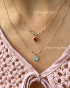 Two layered custom Morse code initial necklaces in 22K gold featuring vibrant red and blue 6mm birthstones, showcasing the adjustable chain lengths[cite: 9].