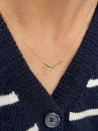 Close-up of a personalized couple's Morse code initial necklace in premium 22K gold plating, centered with a delicate clear heart stone pendant[cite: 9].